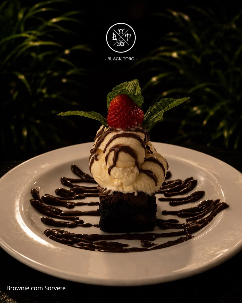 Brownie com sorvete, calda de chocolate, morango e o brasão Black Toro.